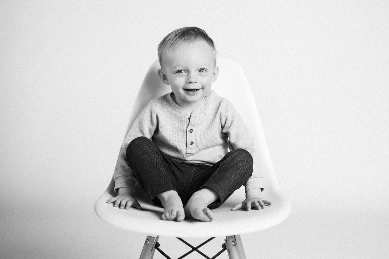 A black and white photo collage showing a baby's expressions and movements during playtime on a white background.