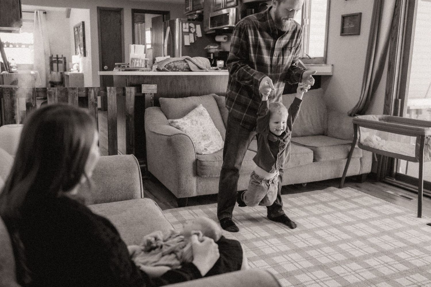 A series of black and white photos showing people sitting in a living room interior.