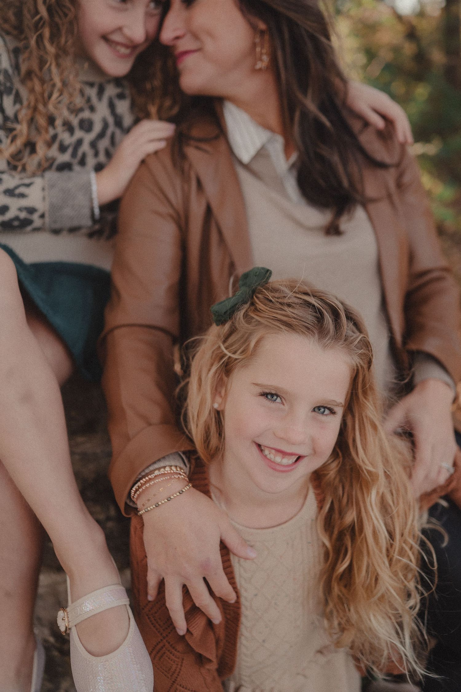 Close-up portrait during autumn family photoshoot with stone wall and natural lighting.