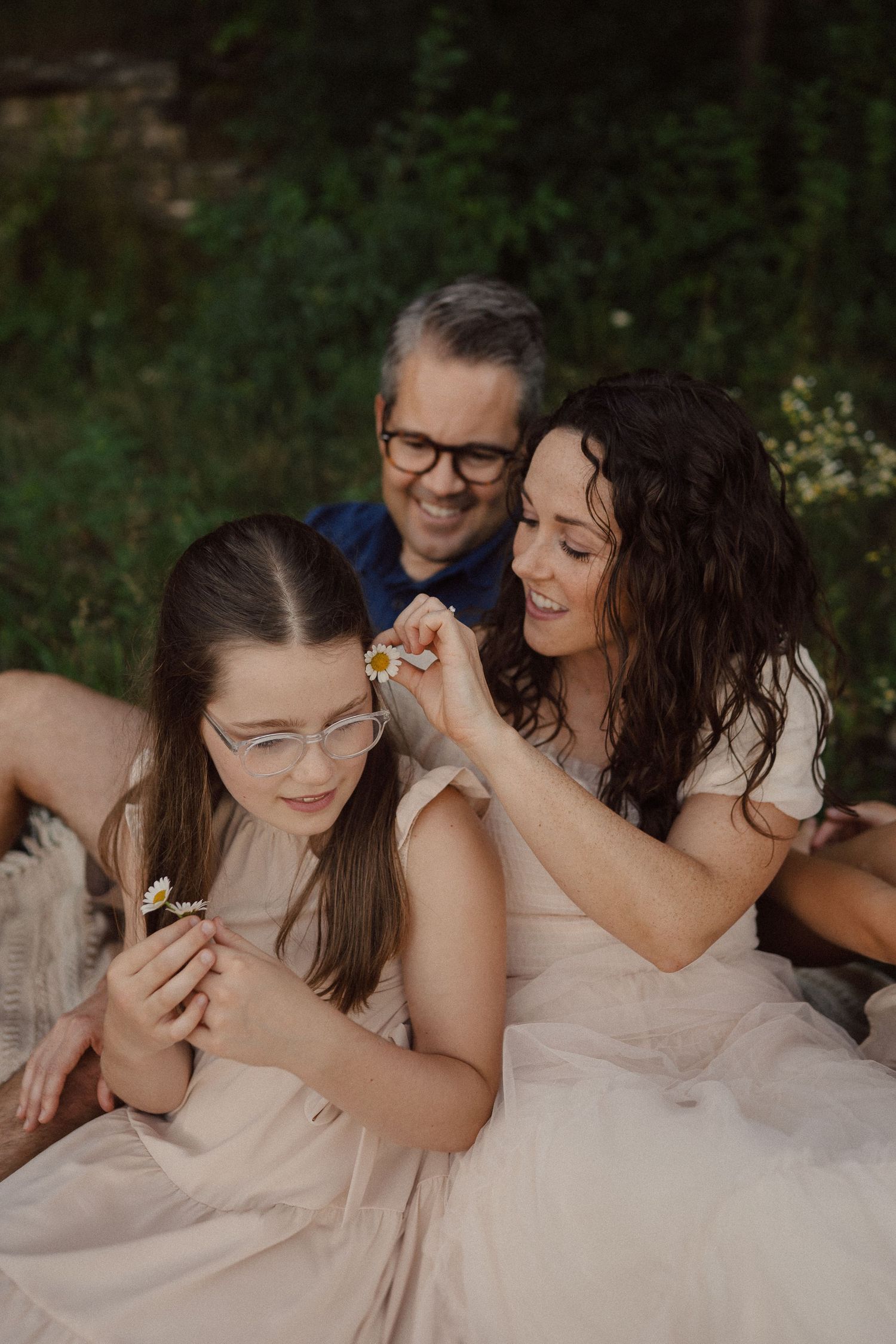 A casual family moment captured during an outdoor photoshoot in nature.