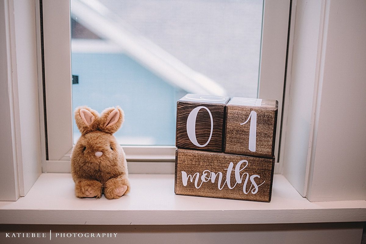 Decorative wooden block calendar and plush bunny displayed on a white windowsill.