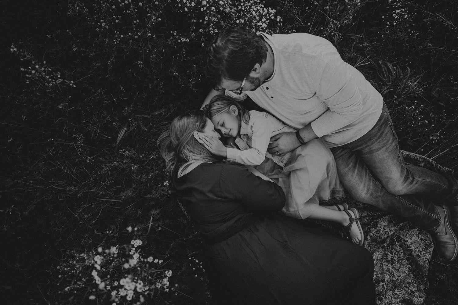 Intimate family moment captured in black and white photography outdoors.