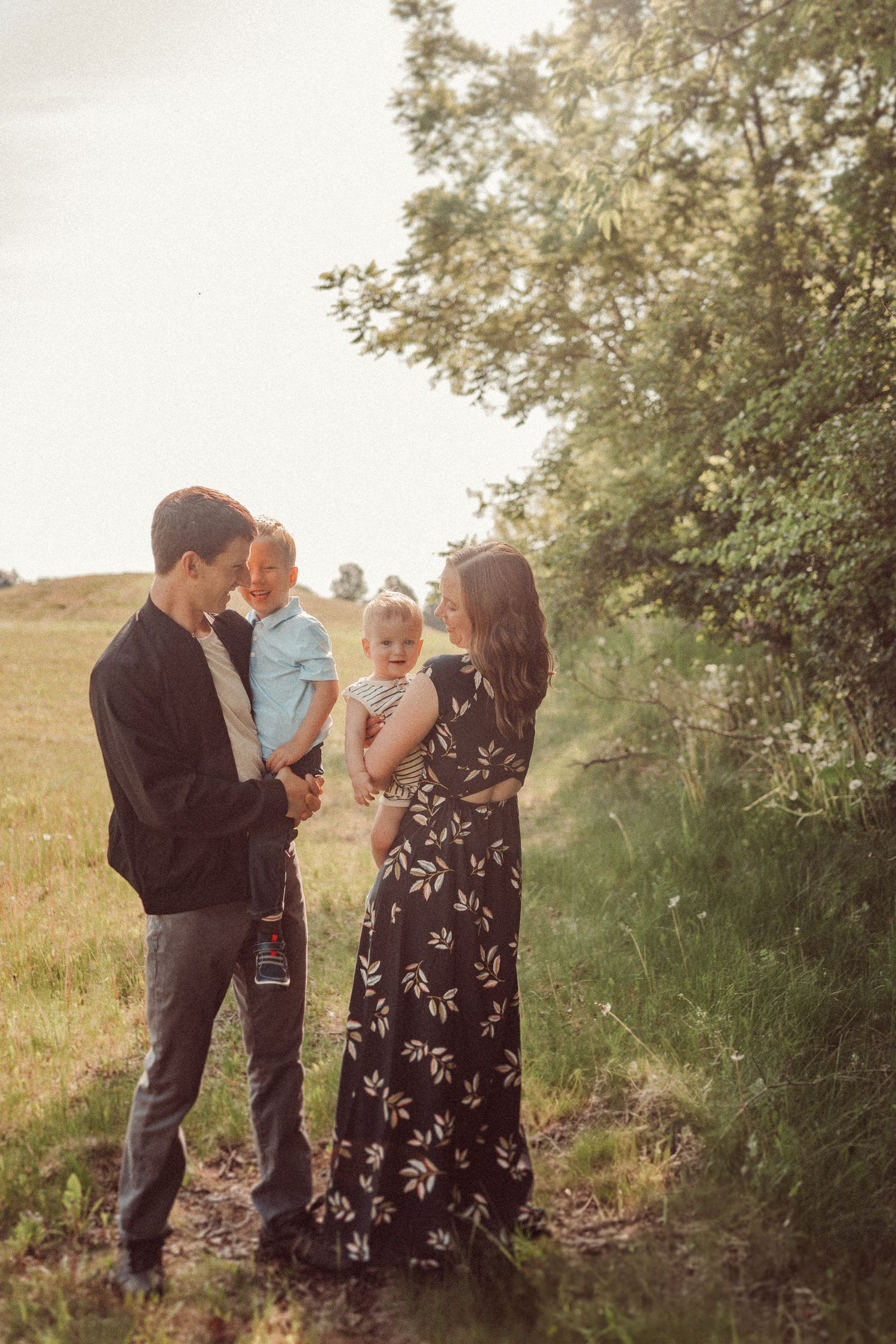 Family gathered together on a scenic hillside path during golden hour.