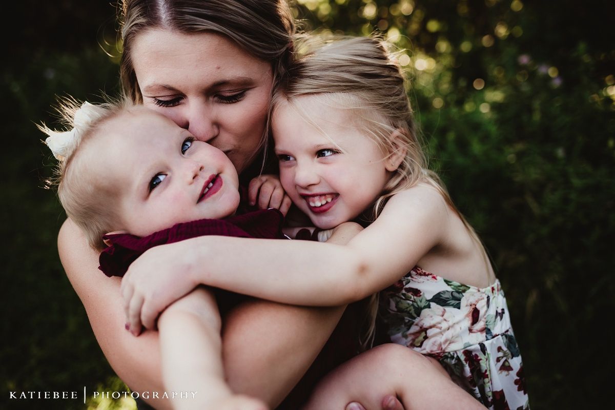 Emotional family portrait showing genuine affection and laughter outdoors.