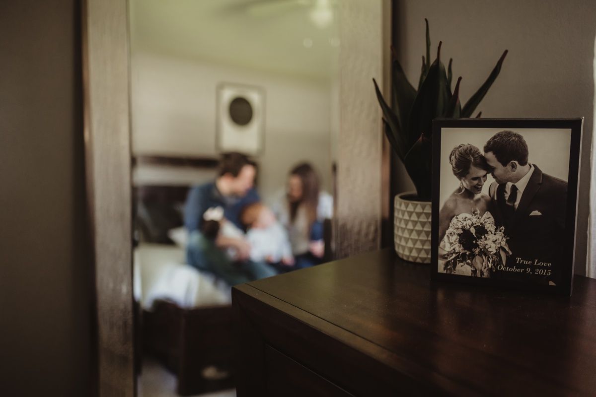 Vintage wedding photo frame with blurred family scene in background.