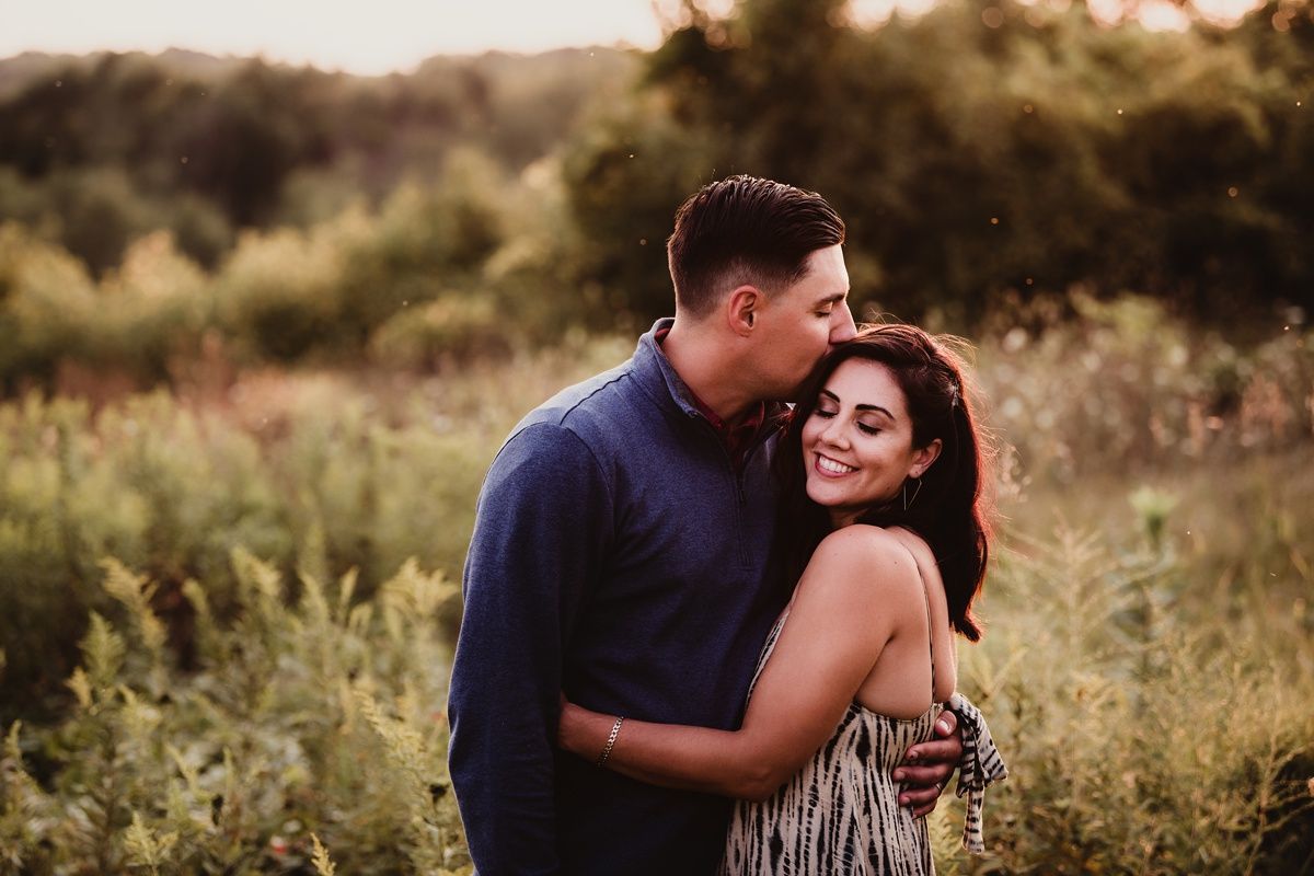 Intimate embrace captured during golden hour in a natural outdoor setting.