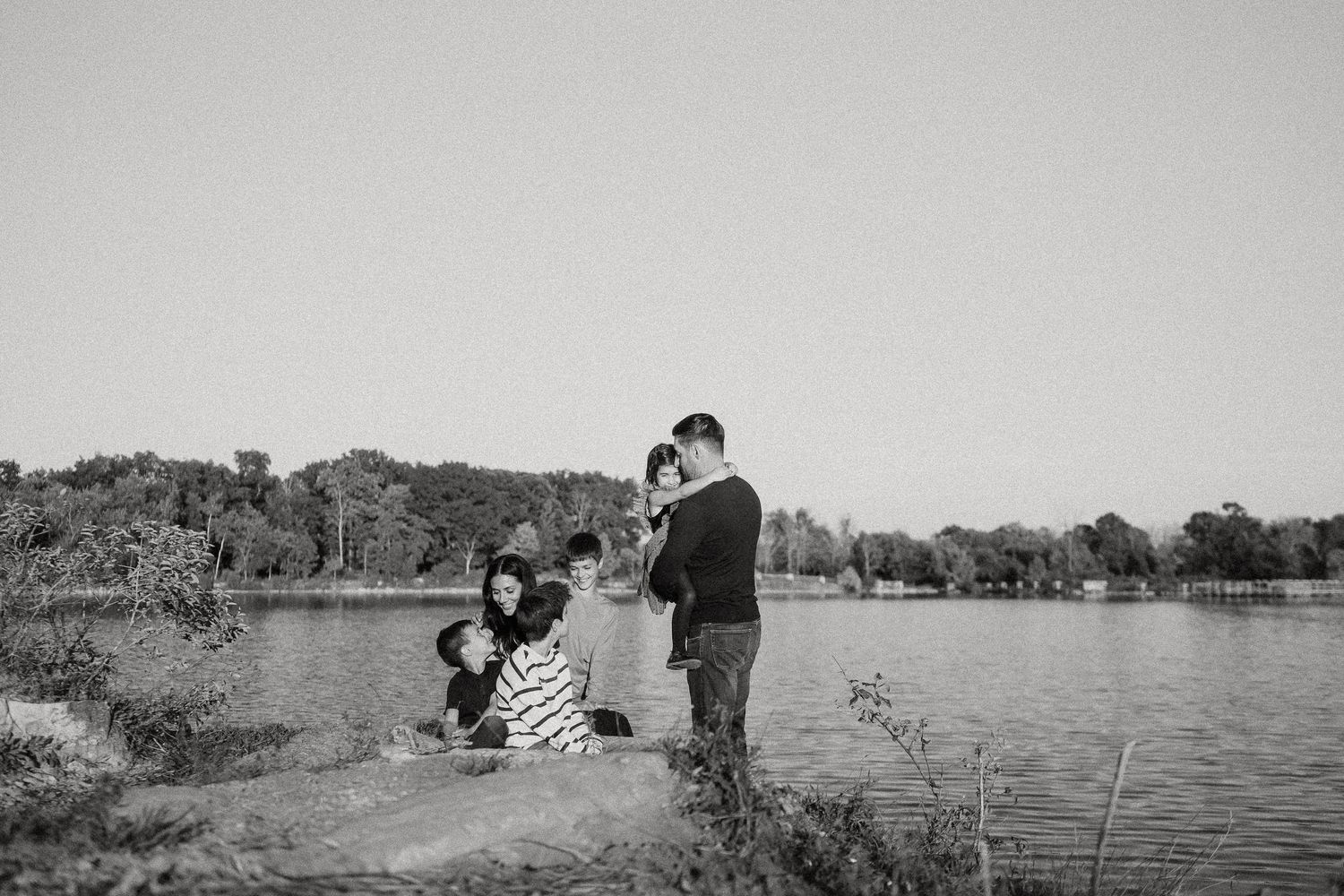 A series of romantic black and white photographs showing couples embracing in various outdoor natural settings.