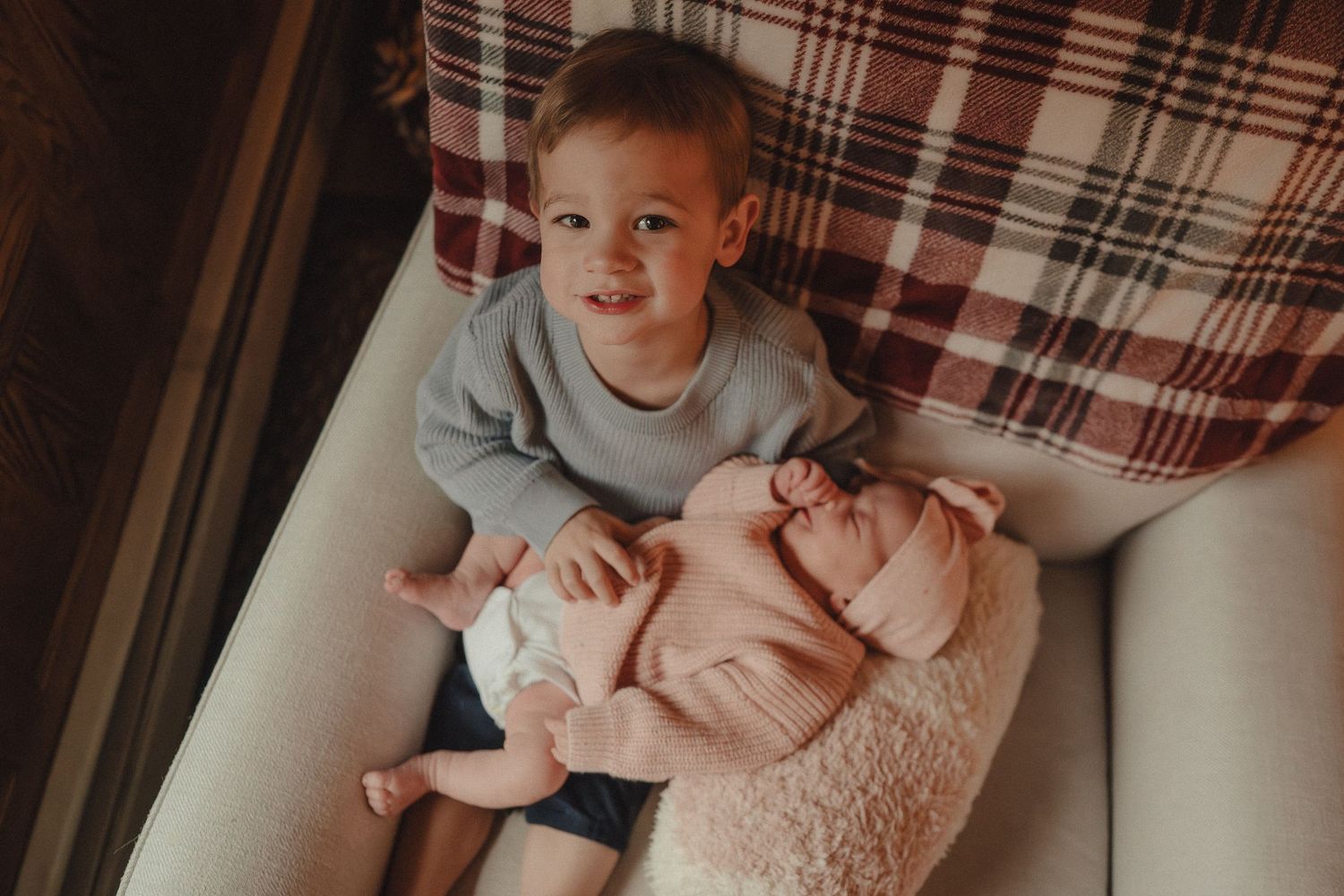 A series of photos showing a baby in plaid bedding and pink clothing lying on a couch or bed.