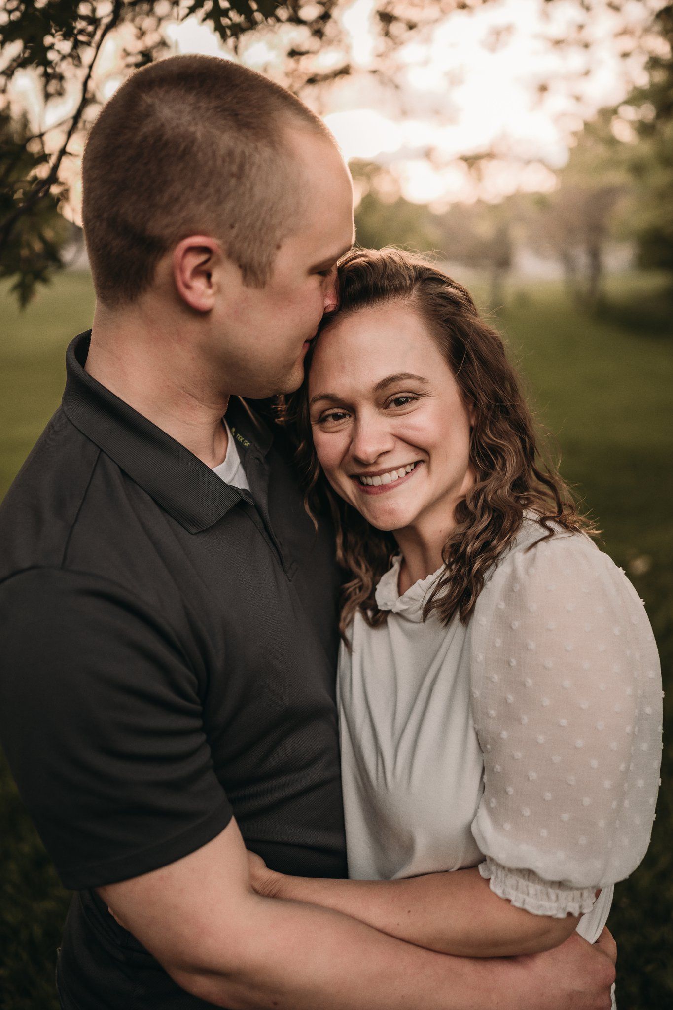Intimate portrait of a couple sharing a tender moment in warm evening light.