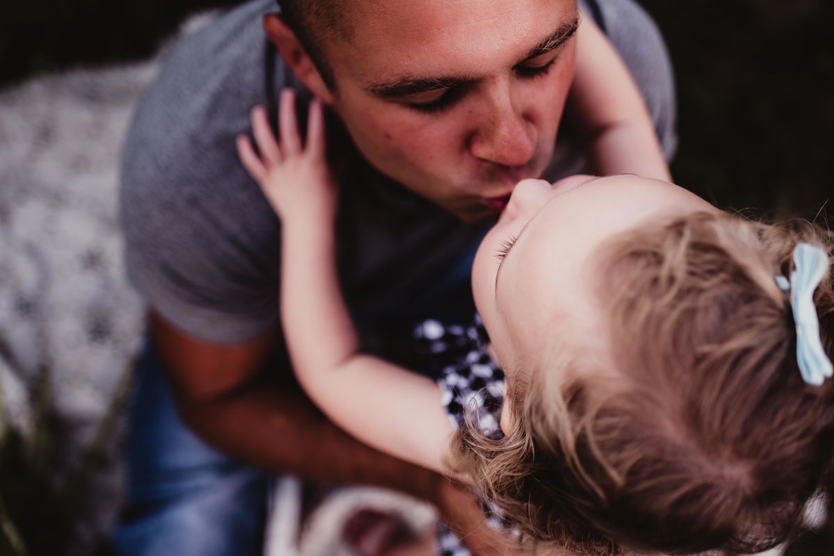A tender moment of affection captured between a parent and toddler in close-up.