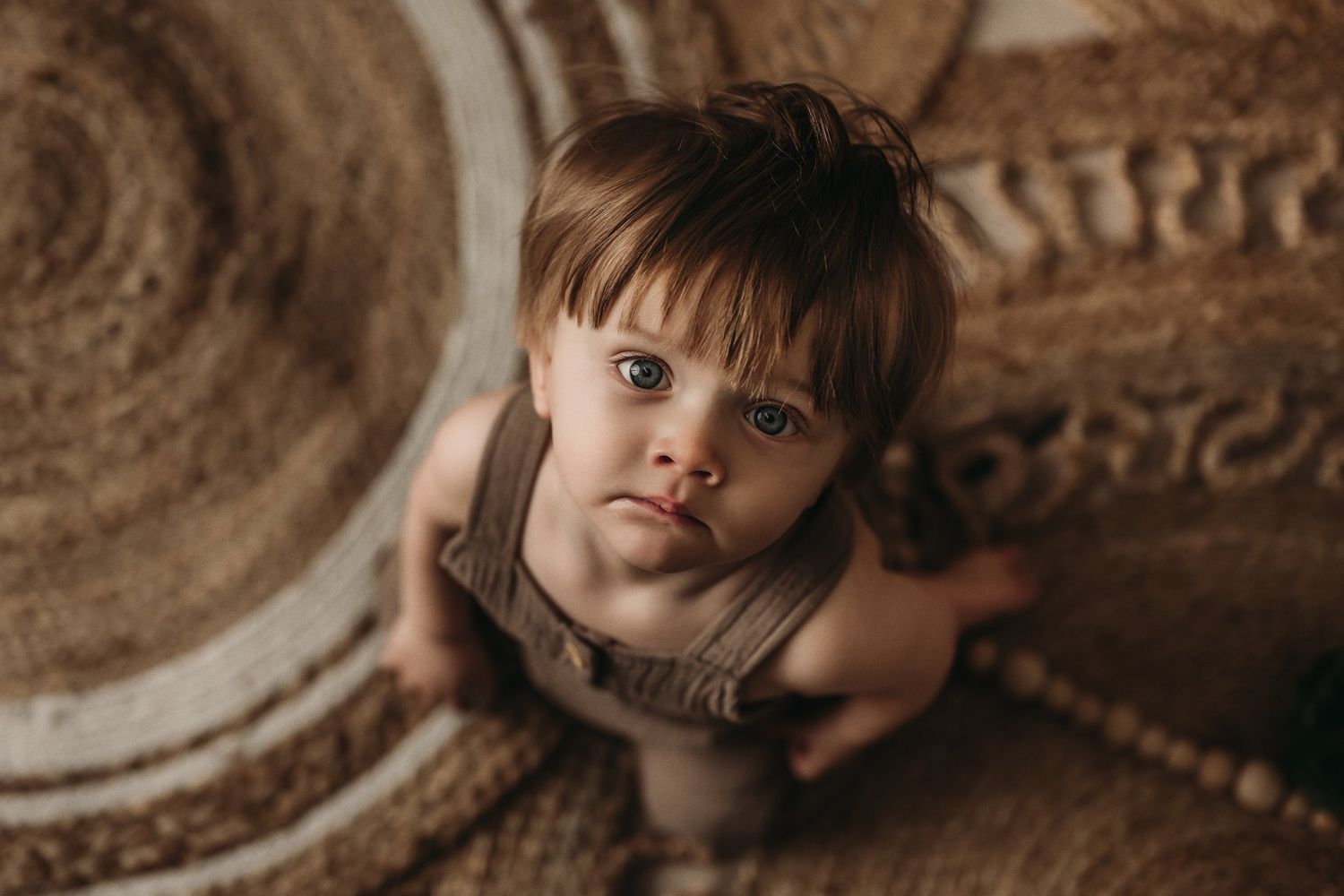 Close-up portrait in warm tones showing a small child against a textured background.
