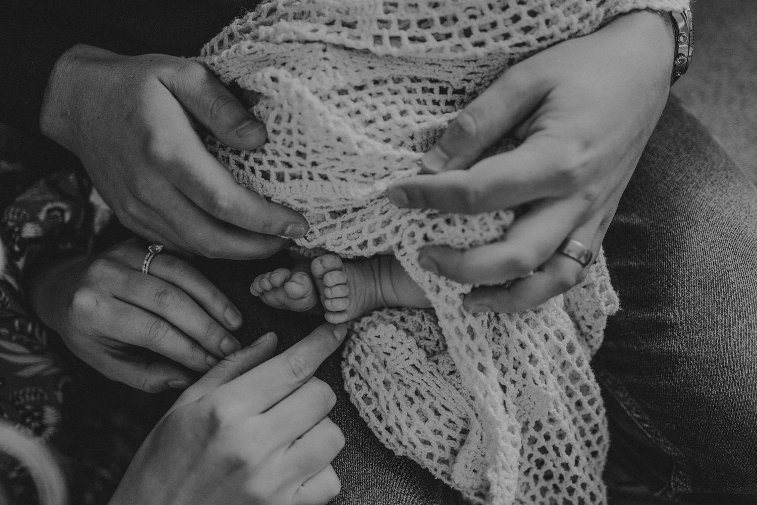 Close-up of hands holding and examining intricate knit fabric patterns.