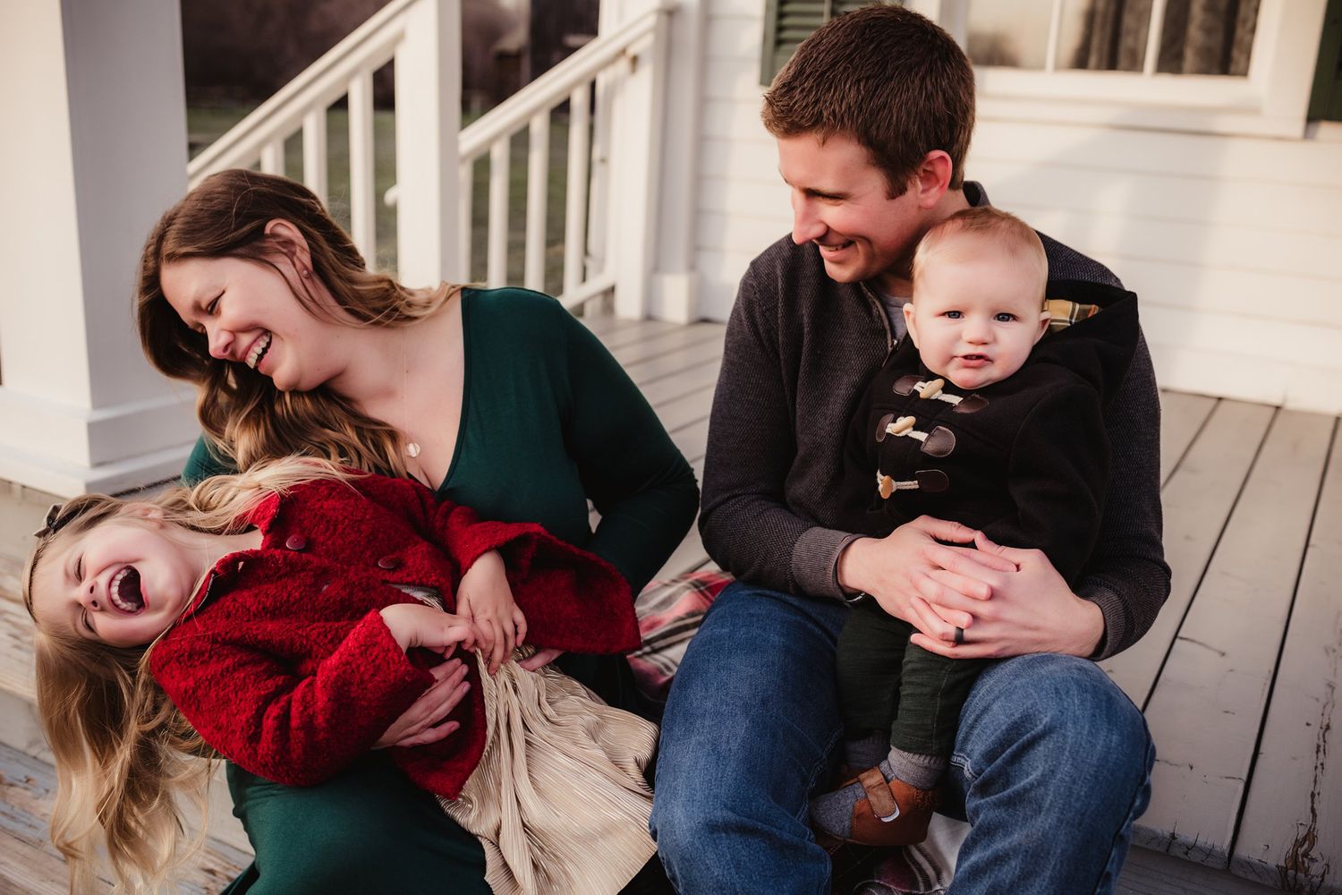 A joyful family photo session with playful moments on a wooden porch.