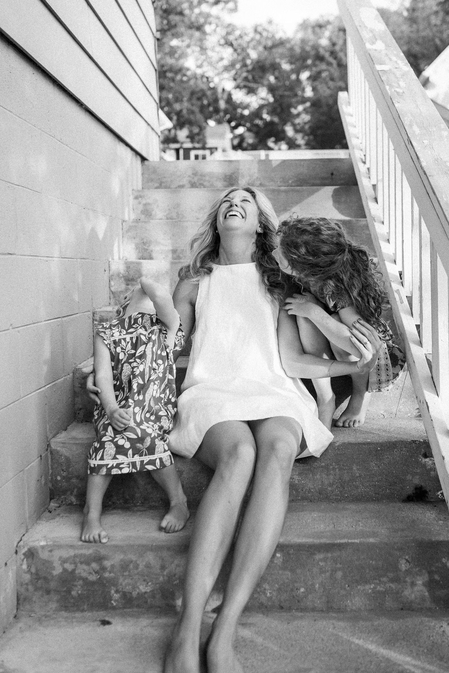 Candid black and white photos of people sitting and laughing on outdoor steps.