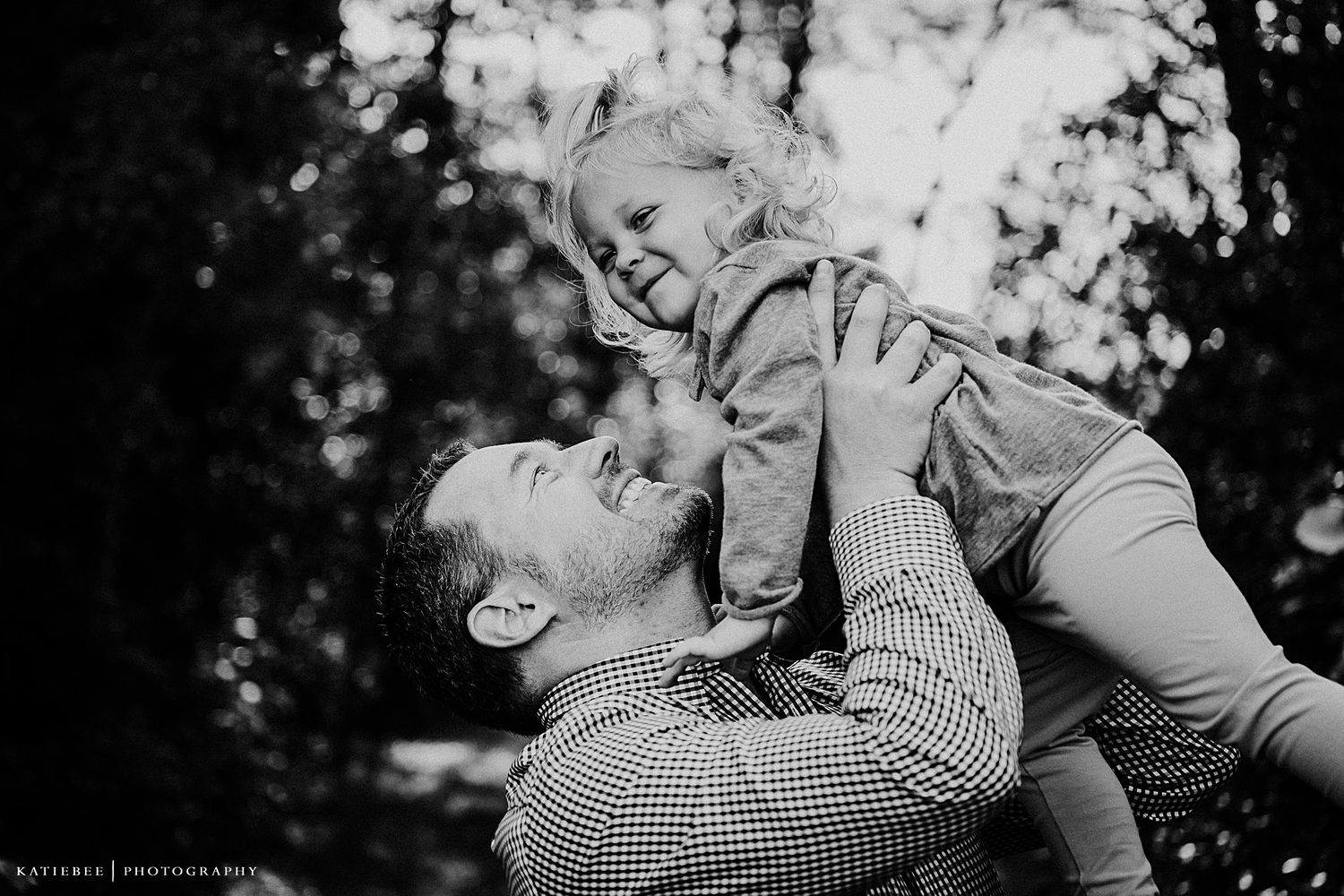 A heartwarming black and white moment of playful interaction outdoors.