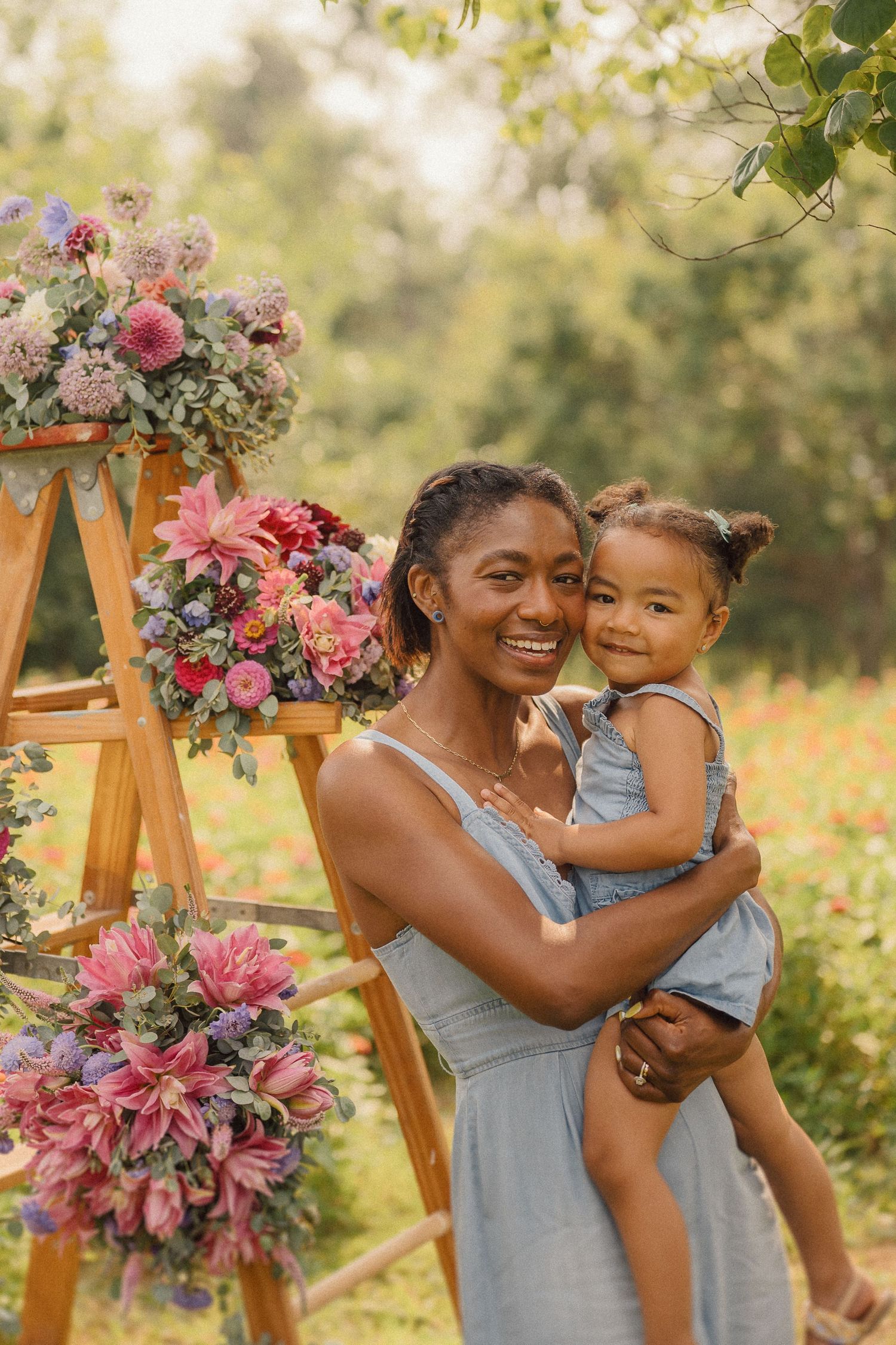 Joyful moments shared under a floral arch with pink and purple blooms in an outdoor garden setting.