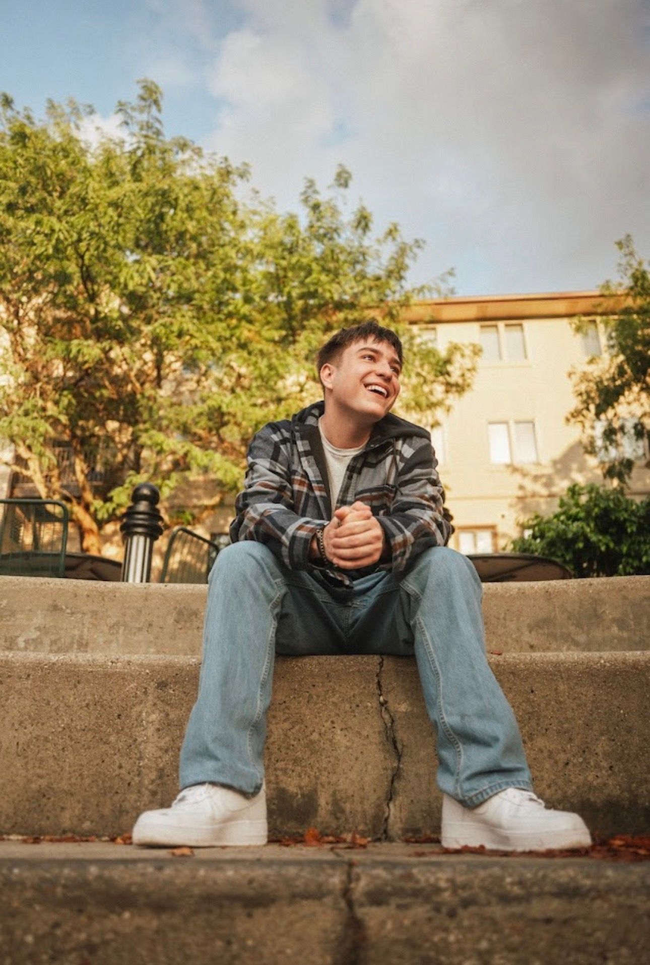 Casual portraits on concrete steps with natural lighting and urban backdrop.