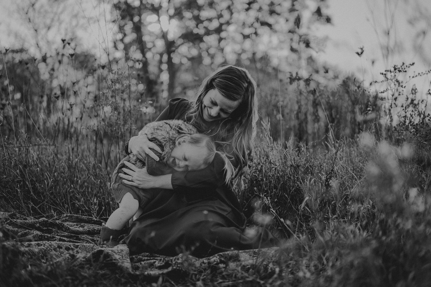 Black and white portrait of tender parenting moment in nature.