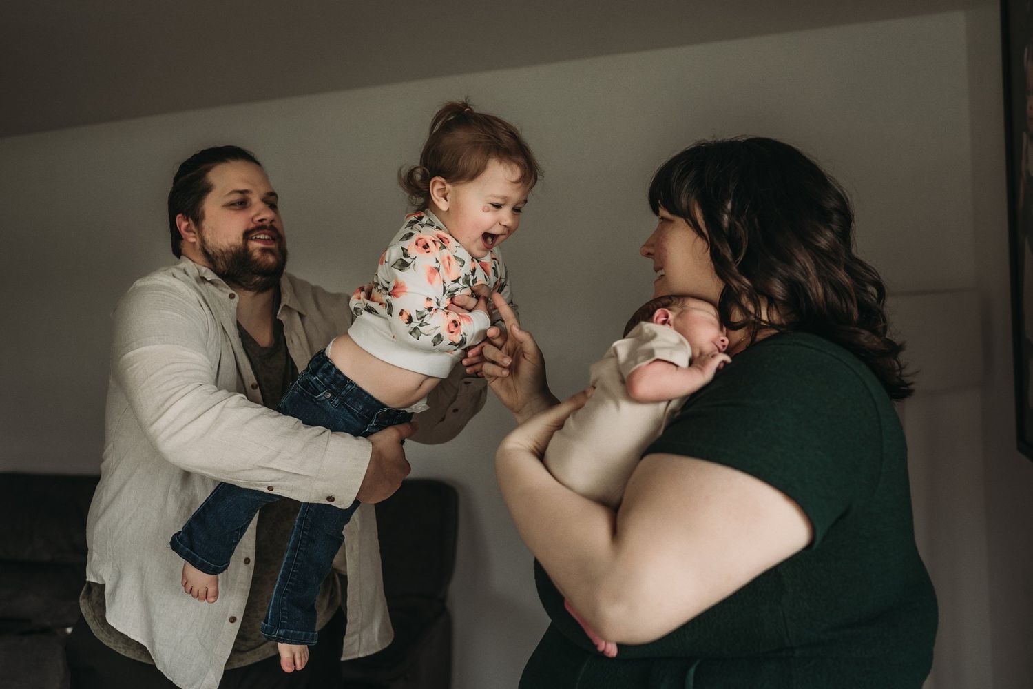 Family moment showing interaction with baby in living room setting.