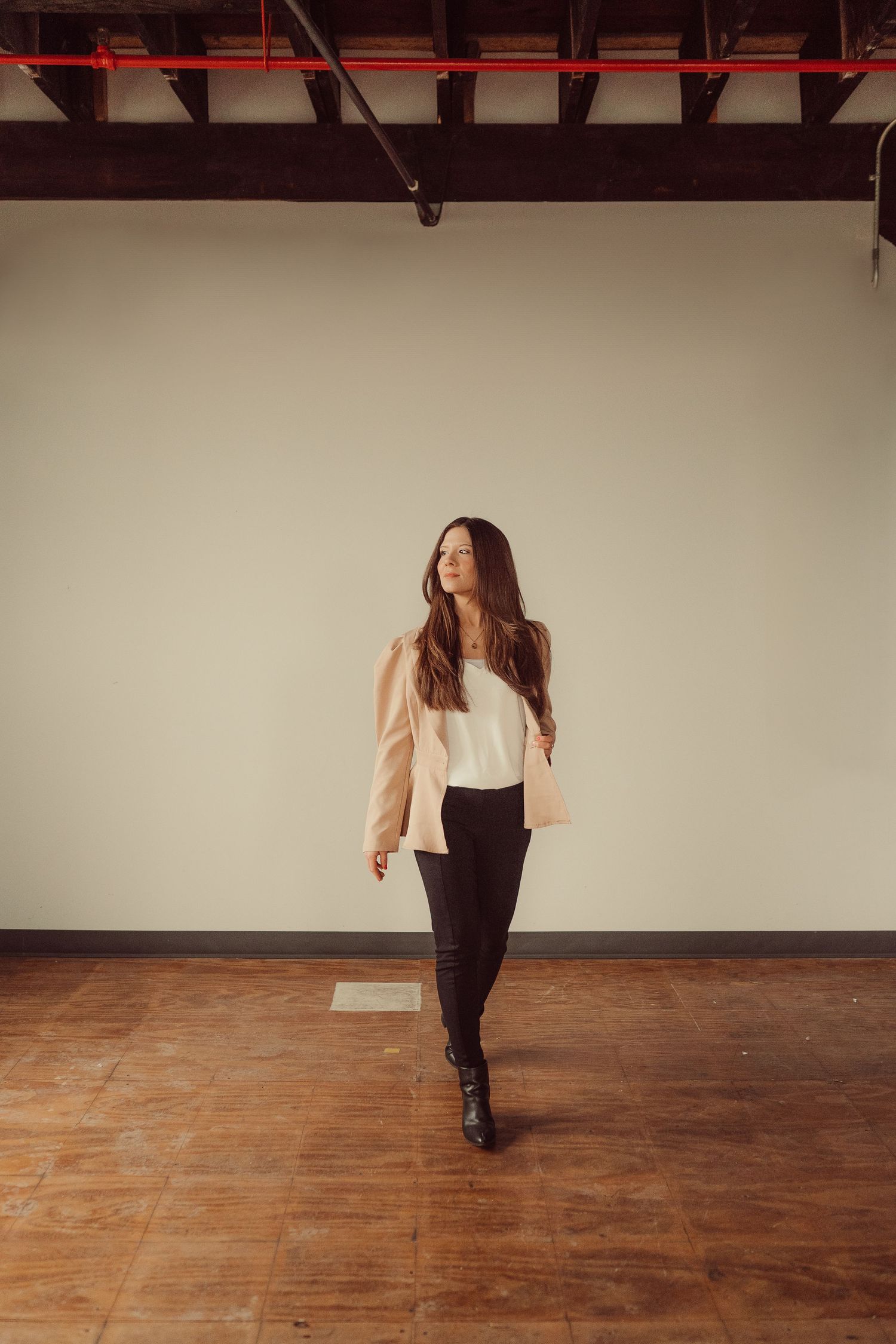 Stylish casual outfit shown walking across hardwood floors in an empty industrial space.
