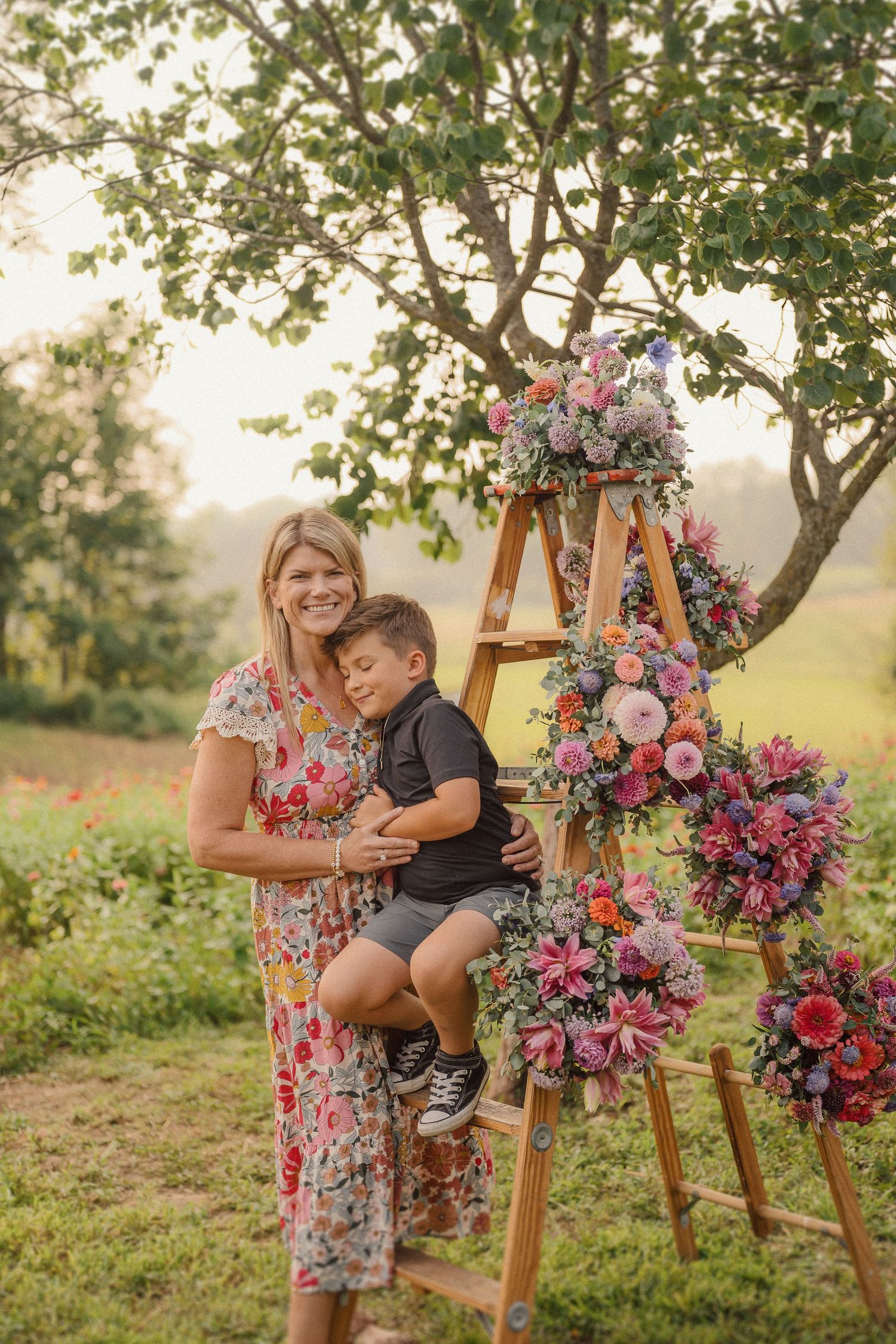 Candid moments captured around a wooden easel adorned with colorful floral arrangements in golden sunlight.