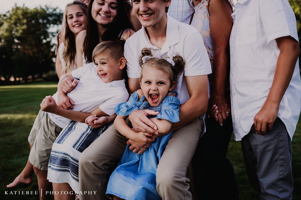 Candid outdoor portrait of a group laughing together on a sunny day.