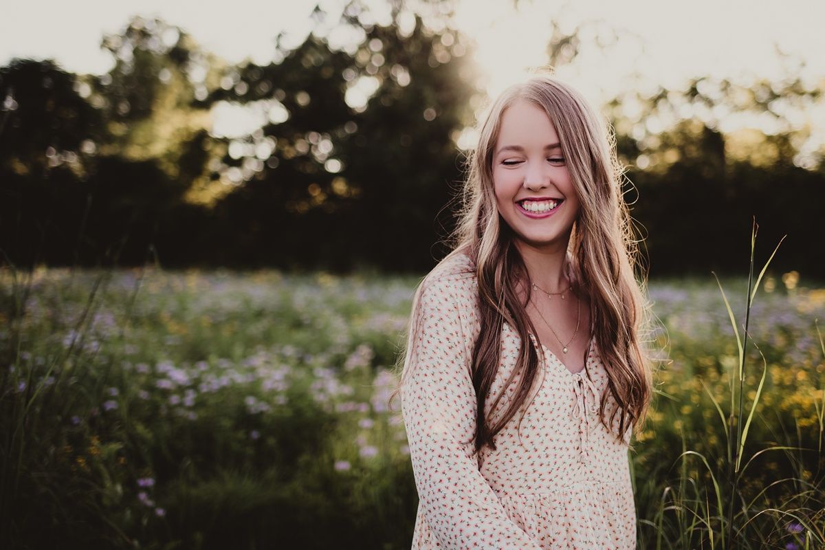 Golden hour portrait in a summer meadow wearing a cream knit sweater.