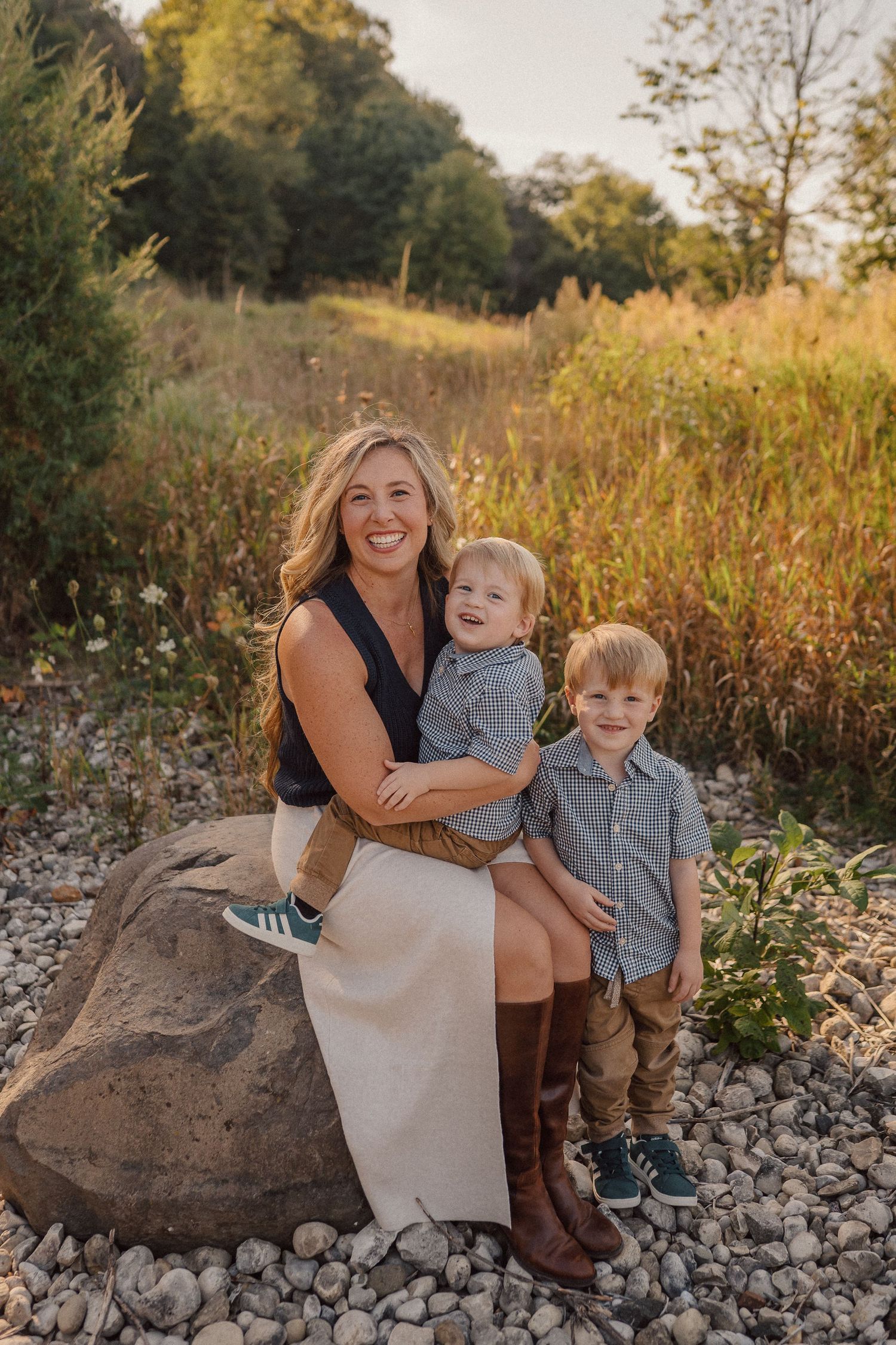 A heartwarming outdoor family portrait session on rocky terrain during golden hour.