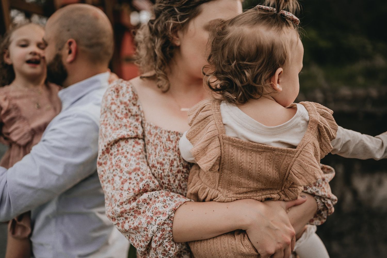 A candid family moment outdoors with everyone dressed in coordinating autumn tones.