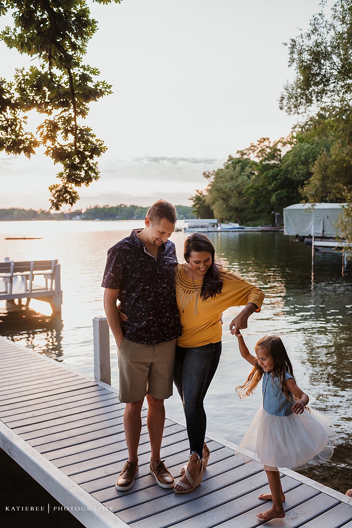 A family enjoying time together on a wooden dock during sunset.