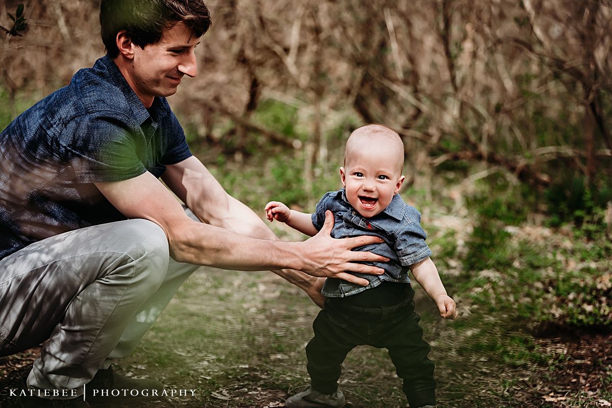 Playful moment captured between adult and child in wooded setting.