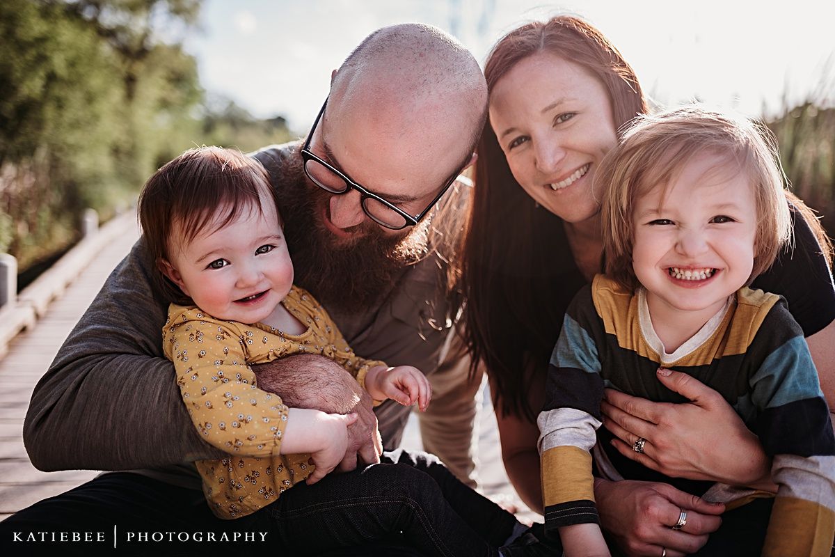 Loving family portrait outdoors with everyone smiling and embracing.
