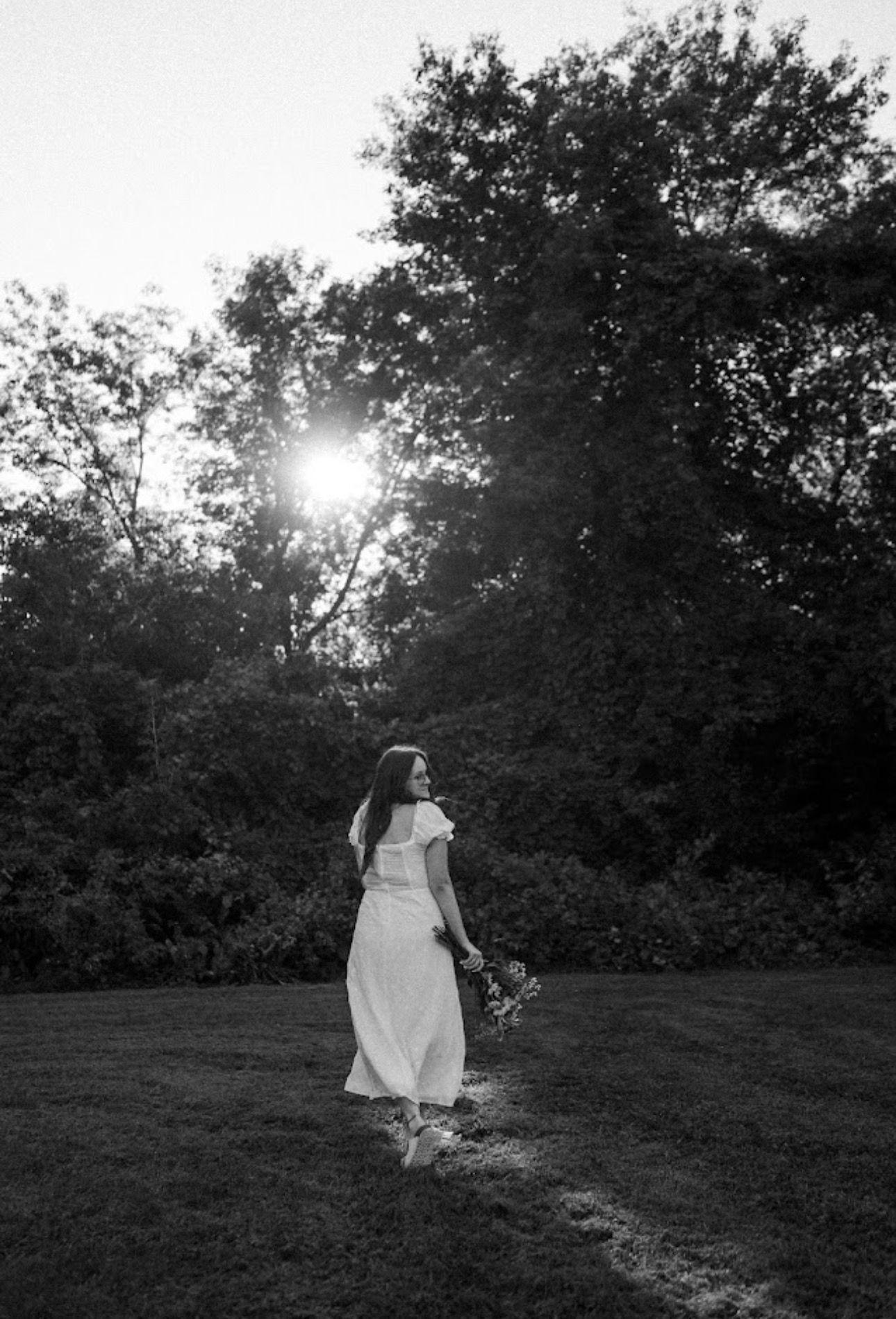 Black and white artistic portraits in a sunlit meadow with dramatic backlighting.