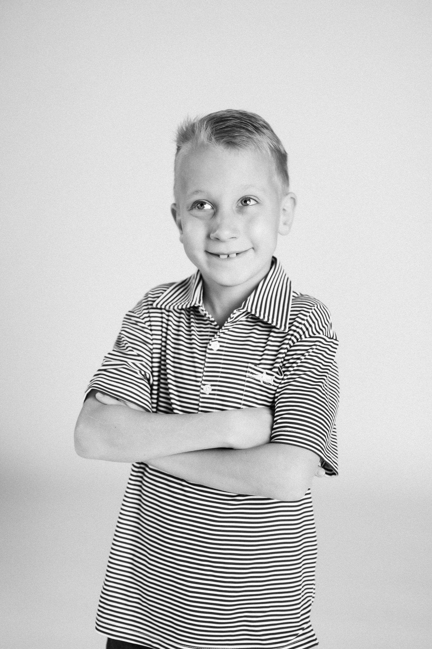 Black and white portrait series showing playful expressions in a striped polo shirt against a light background.