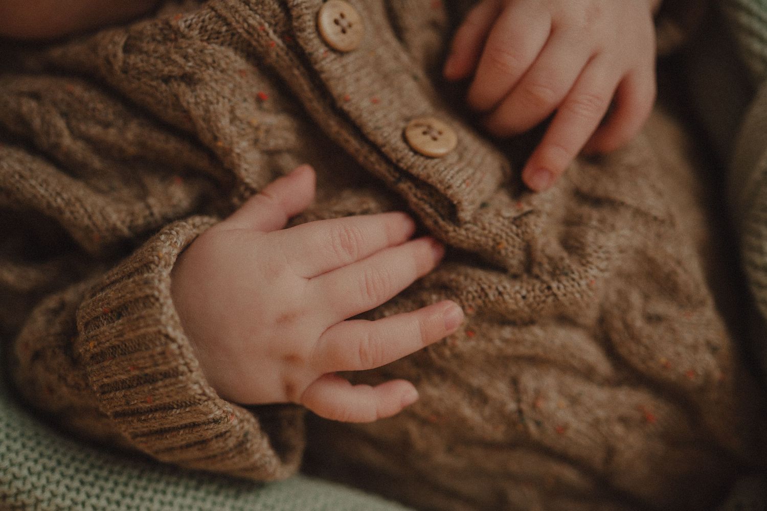 Close-up detail shots of brown cable knit sweater texture and hands.