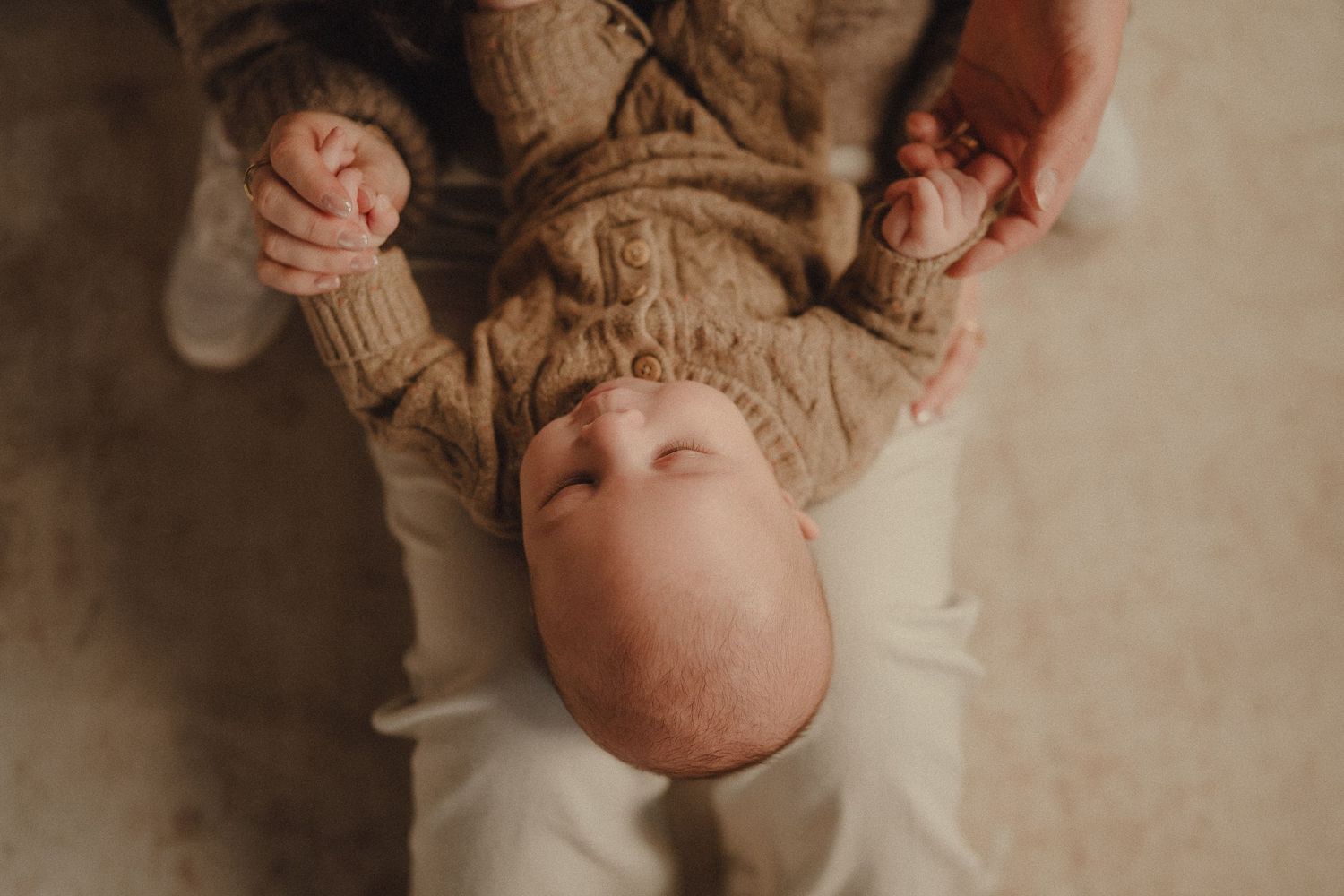 A series of warm-toned photographs showing close-up details of a baby in soft knit clothing.