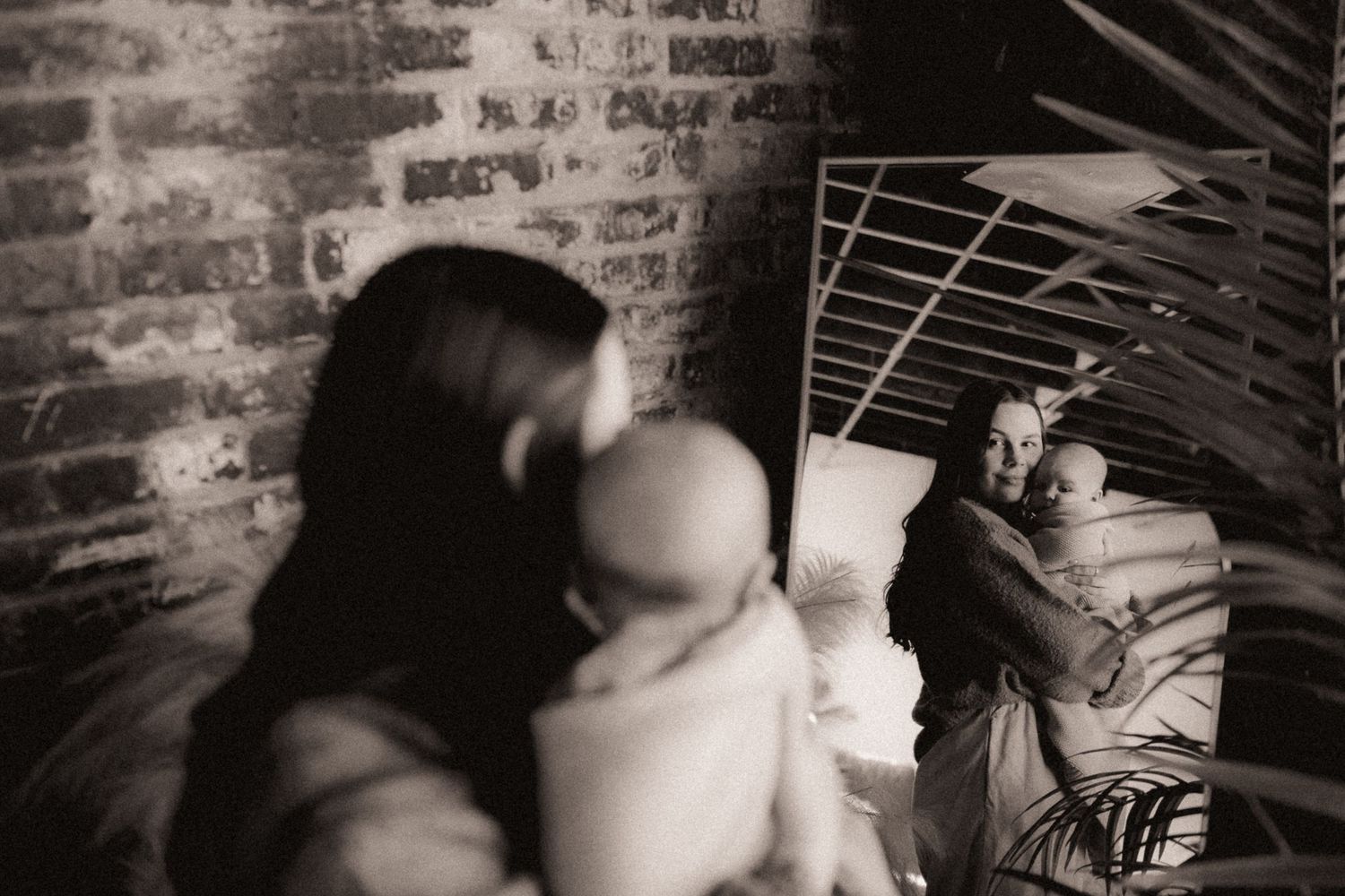 An intimate black and white photograph capturing a quiet moment between parent and infant.