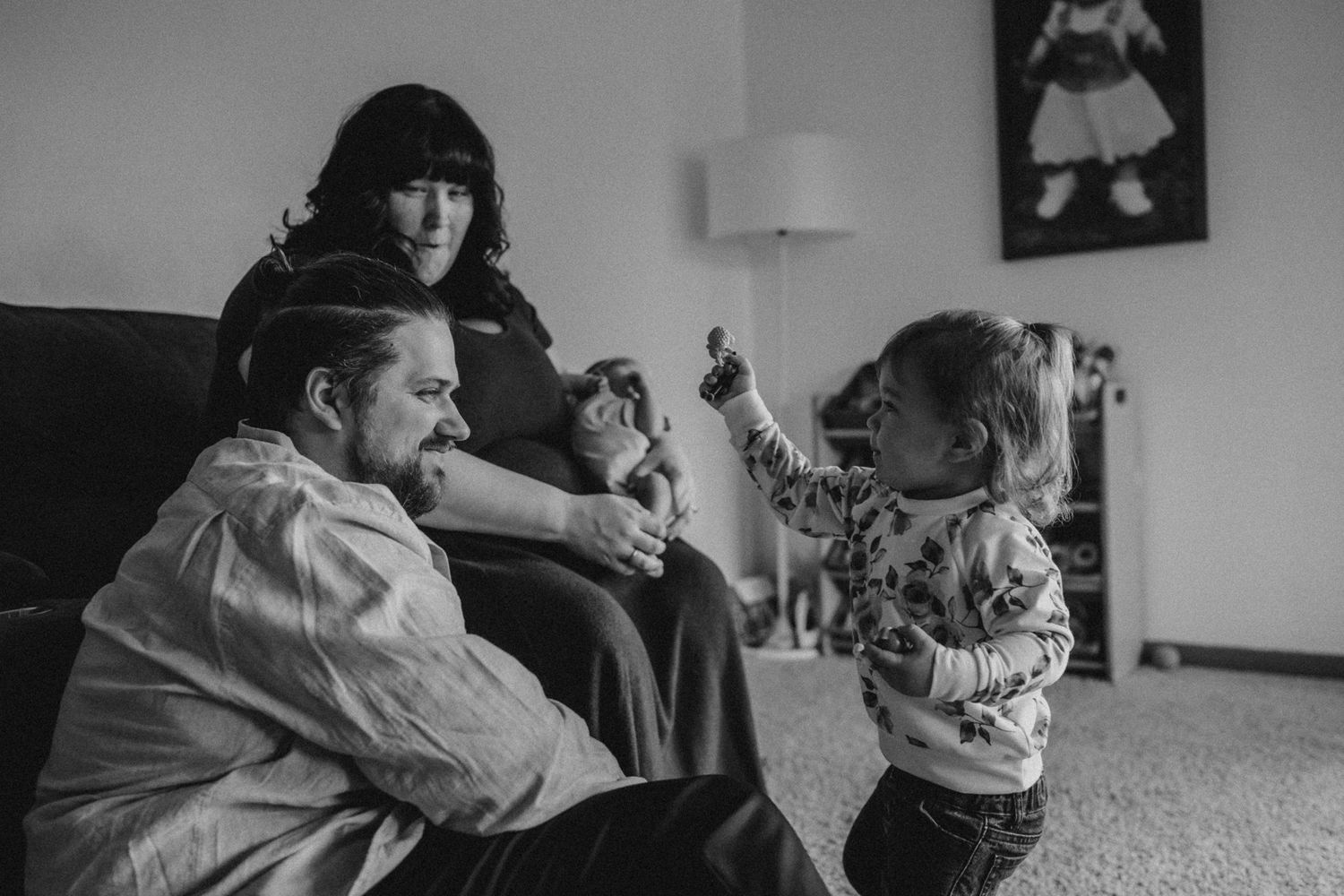 Family moment captured in black and white as toddler plays energetically.