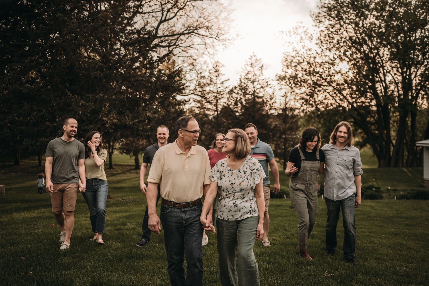 A casual group walks together through a park during golden hour.