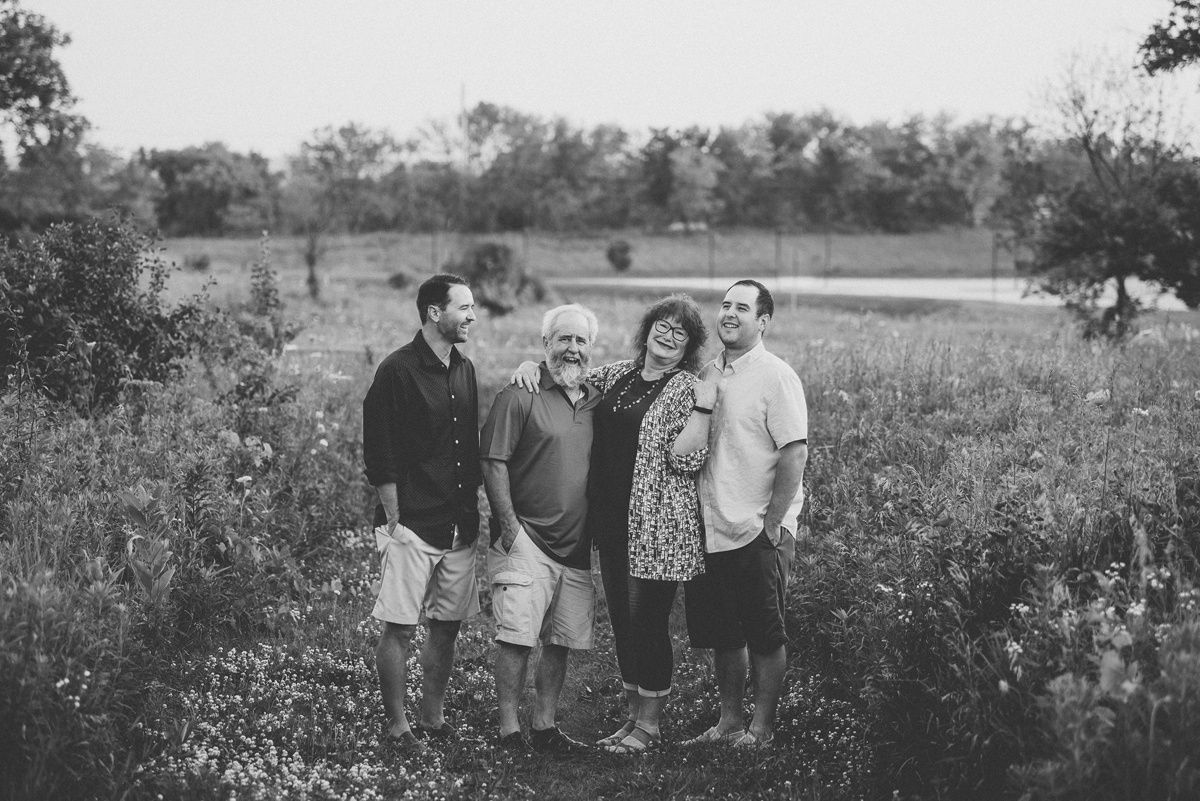 A black and white photo of a small group posing together in a rural field setting.