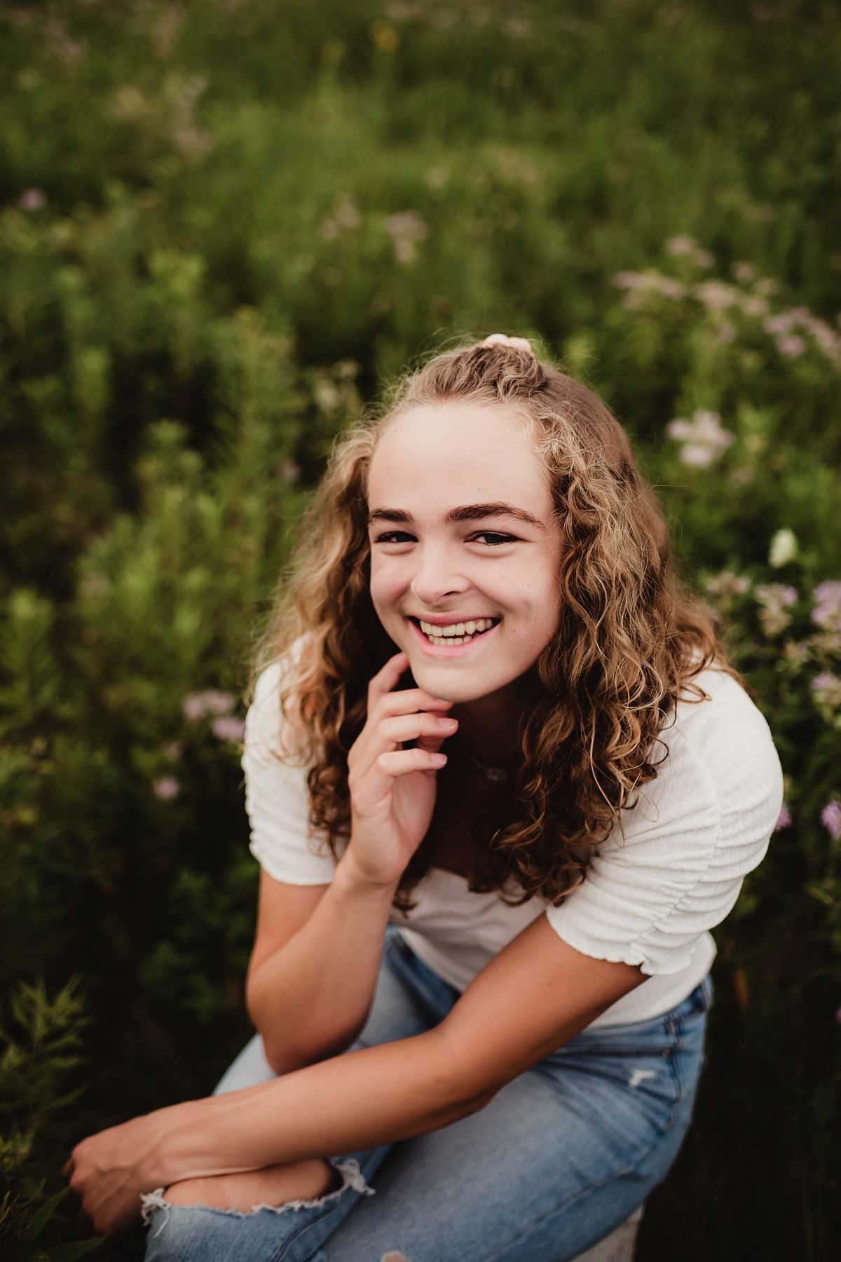 Casual outdoor portrait in a natural garden setting with warm lighting.