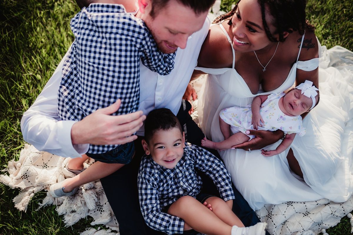 Candid family photo showing tender moments of connection outdoors.