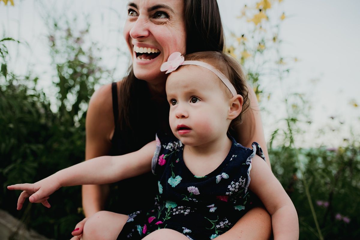 Candid moment of laughter and pointing while enjoying time in a garden setting.