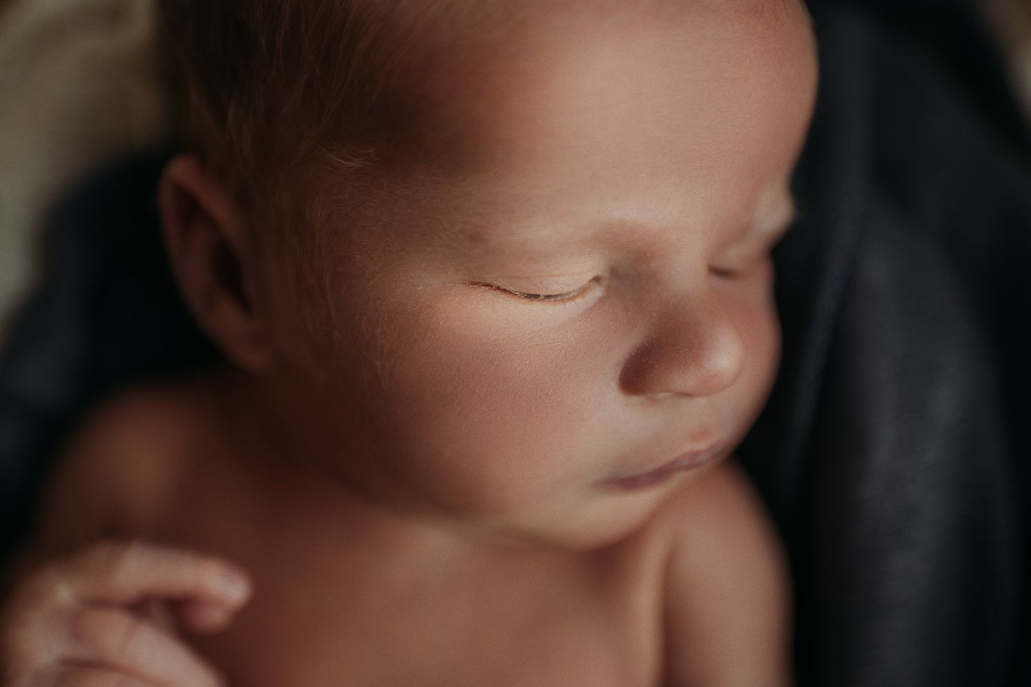Close-up of a sleeping newborn's face with delicate features.