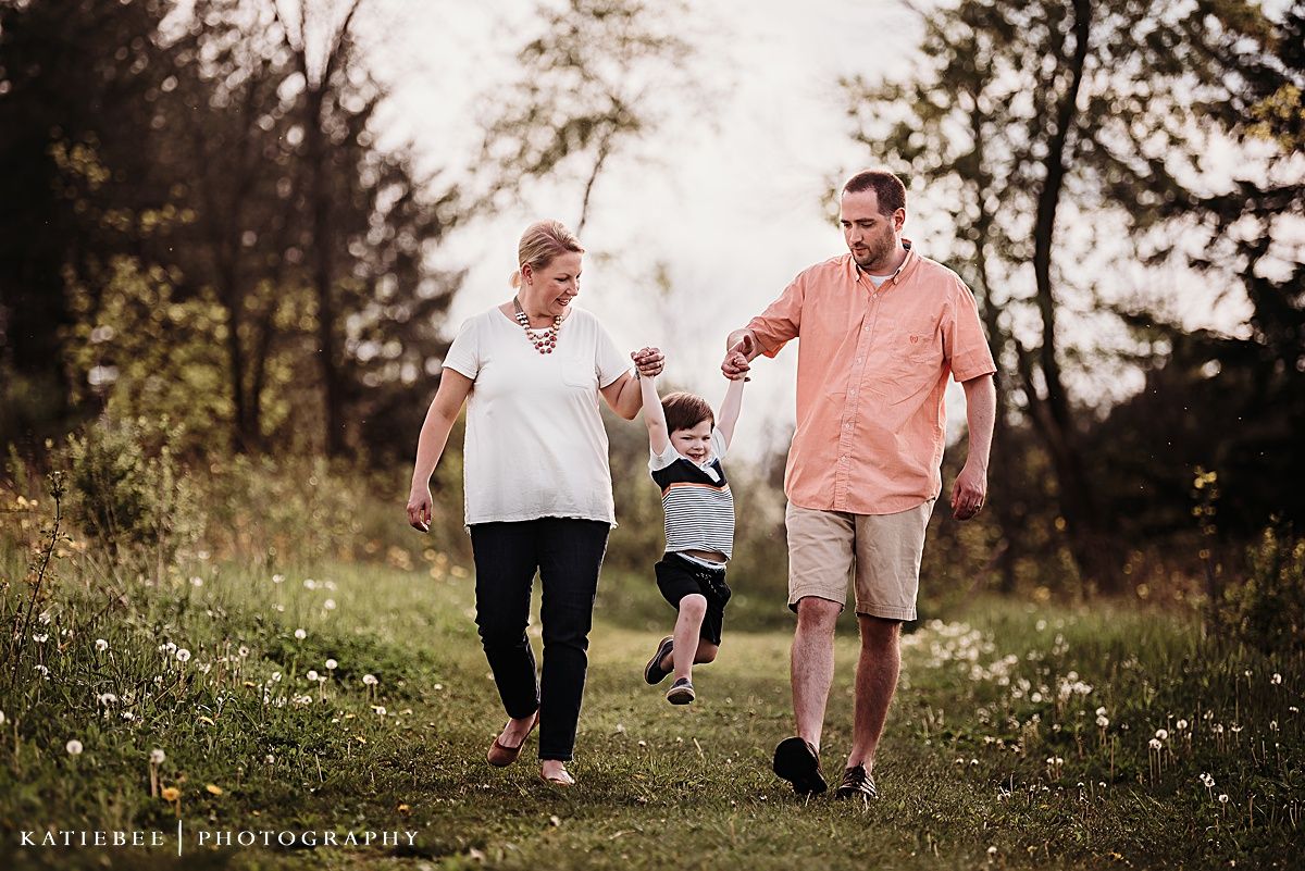 Family enjoying a walk together through a wildflower meadow at sunset.