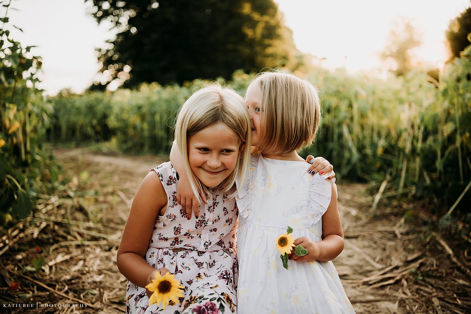Sweet moment between children sharing secrets and sunflowers on a summer evening.