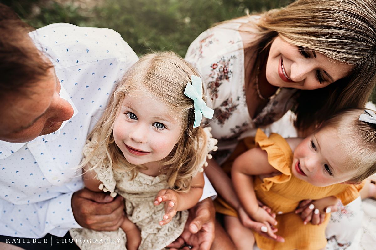 Intimate family portrait outdoors with coordinated neutral and mustard yellow outfits.