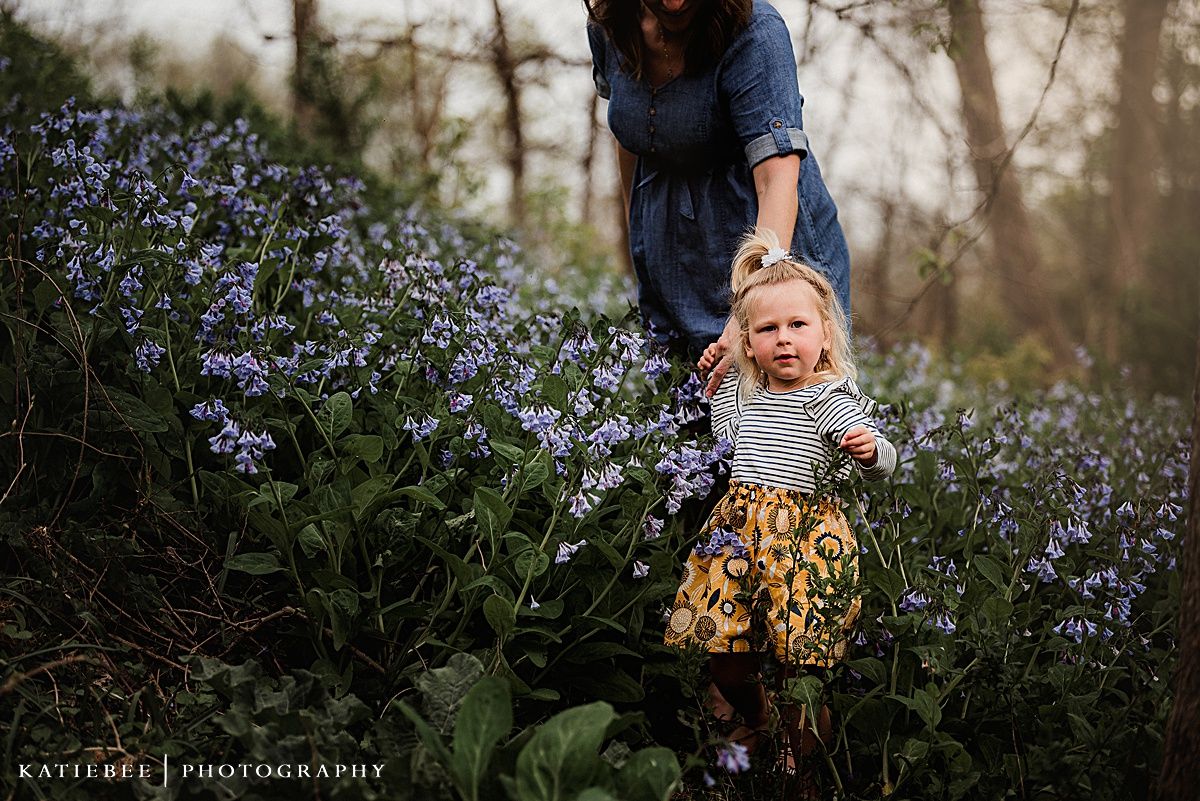 Two people share a delightful moment among purple wildflowers in a natural outdoor setting.