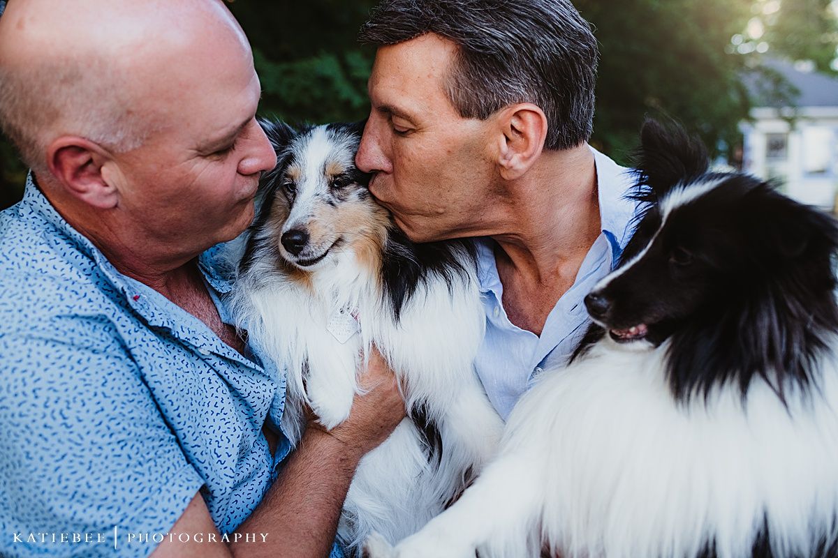 Two people share loving kisses with their beautiful border collie dogs.