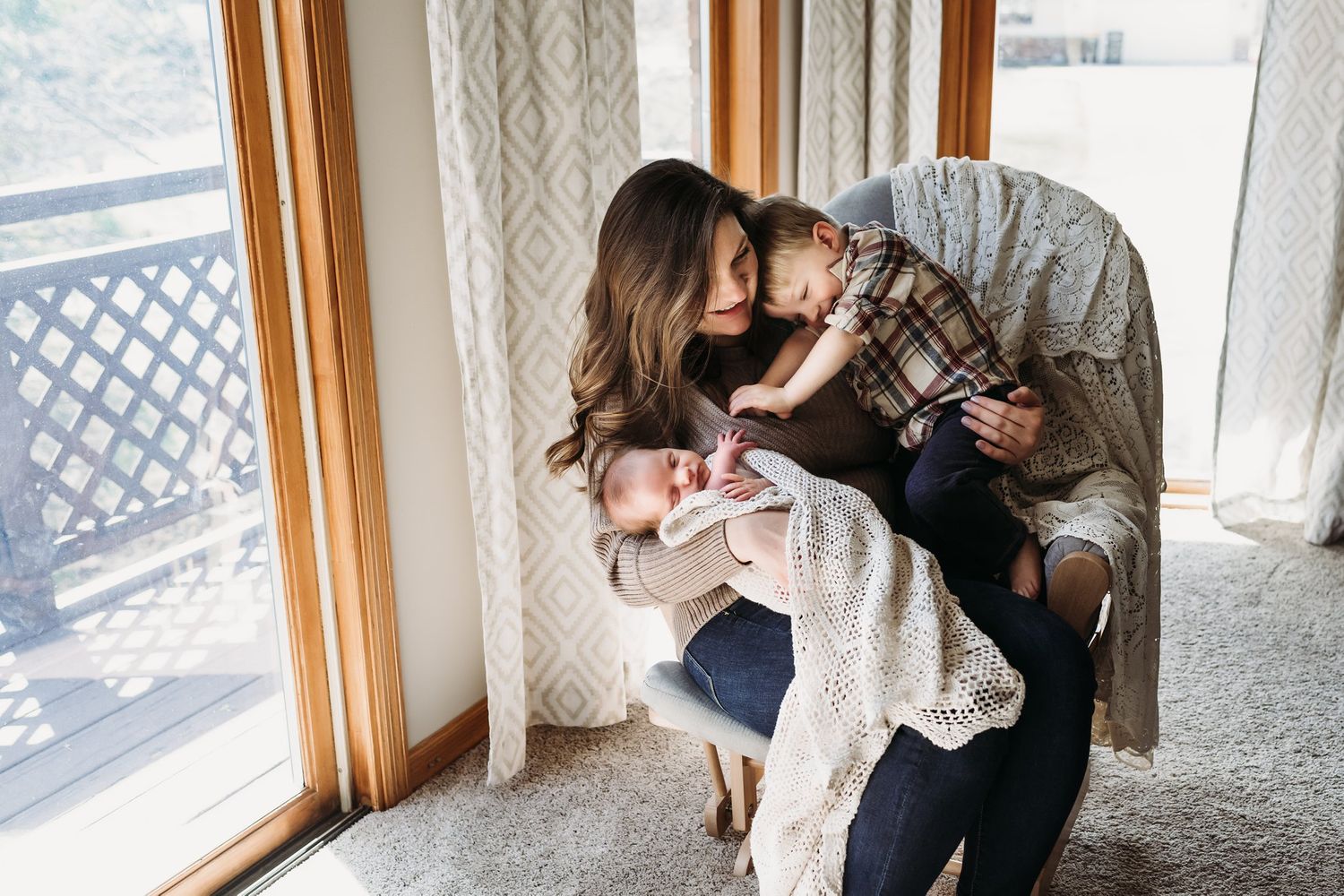 Sweet family moment captured by sunlit window in comfortable home setting.